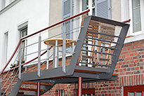 Balkongel�nder, Stahlbalkon mit einer halbgewendelten Stahltreppe aus Stahl und einem Belag aus Holz.  - (c) by Metallbau Fritz