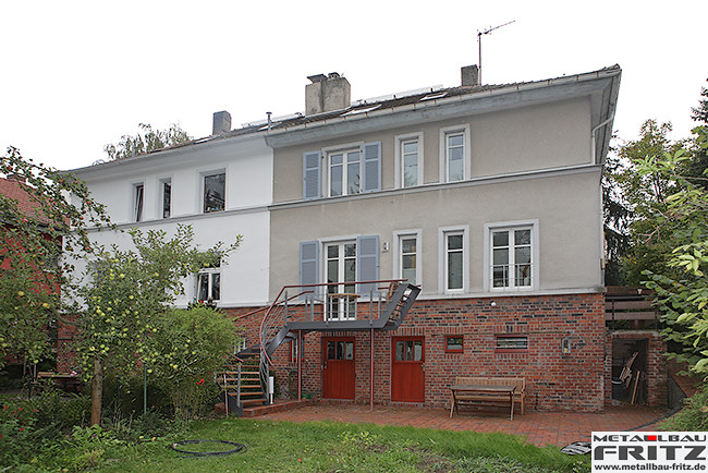 Stahlbalkon mit einem gewendelten Treppenaufgang und einem Holzbelag - Stahlbalkon / Balkongelnder 37-04  -  (c) by Metallbau Fritz