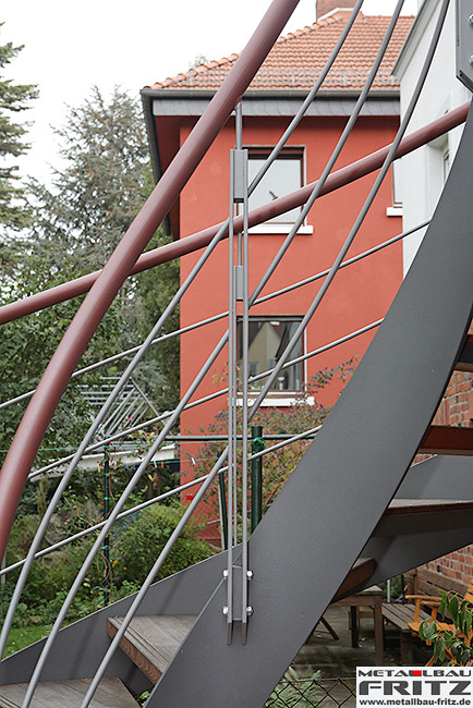 Stahlbalkon mit einem gewendelten Treppenaufgang und einem Holzbelag - Stahlbalkon / Balkongelnder 37-16  -  (c) by Metallbau Fritz