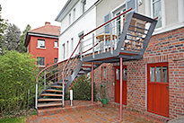 Stahlbalkon mit einem gewendelten Treppenaufgang und einem Holzbelag - (c) by Metallbau Fritz