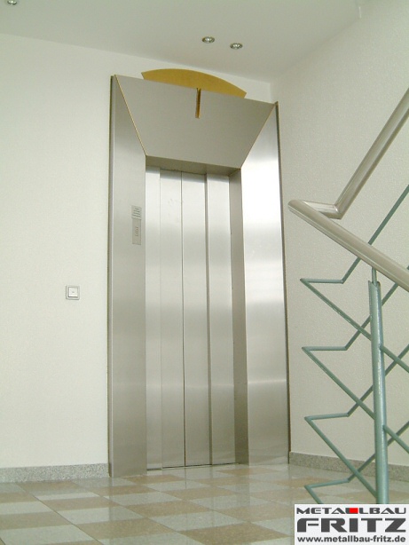 Individuell gestaltete Aufzugsverkleidung aus Edelstahl mit einem Designelement aus Messing - Aufzugsverkleidung 14-01  -  (c) by Metallbau Fritz