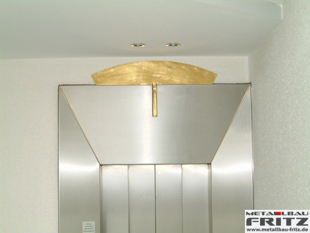 Individuell gestaltete Aufzugsverkleidung aus Edelstahl mit einem Designelement aus Messing - Aufzugsverkleidung 14-04  -  (c) by Metallbau Fritz
