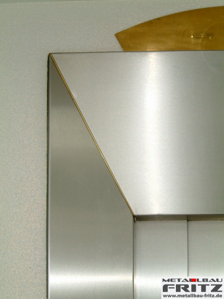 Individuell gestaltete Aufzugsverkleidung aus Edelstahl mit einem Designelement aus Messing - Aufzugsverkleidung 14-07  -  (c) by Metallbau Fritz