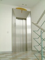 Individuell gestaltete Aufzugsverkleidung aus Edelstahl mit einem Designelement aus Messing 14-01