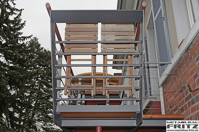 Stahlbalkon mit einem gewendelten Treppenaufgang und einem Holzbelag - Stahlbalkon / Balkongelnder 37-07  -  (c) by Metallbau Fritz